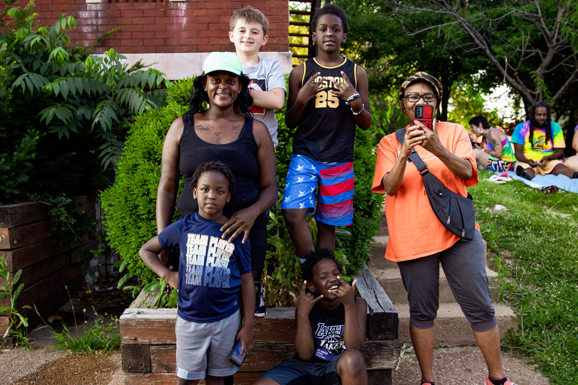 Four children and two adults at a mural painting event posing for a photo on a stoop on Meramec Street in Downtown Dutchtown, St. Louis, MO.